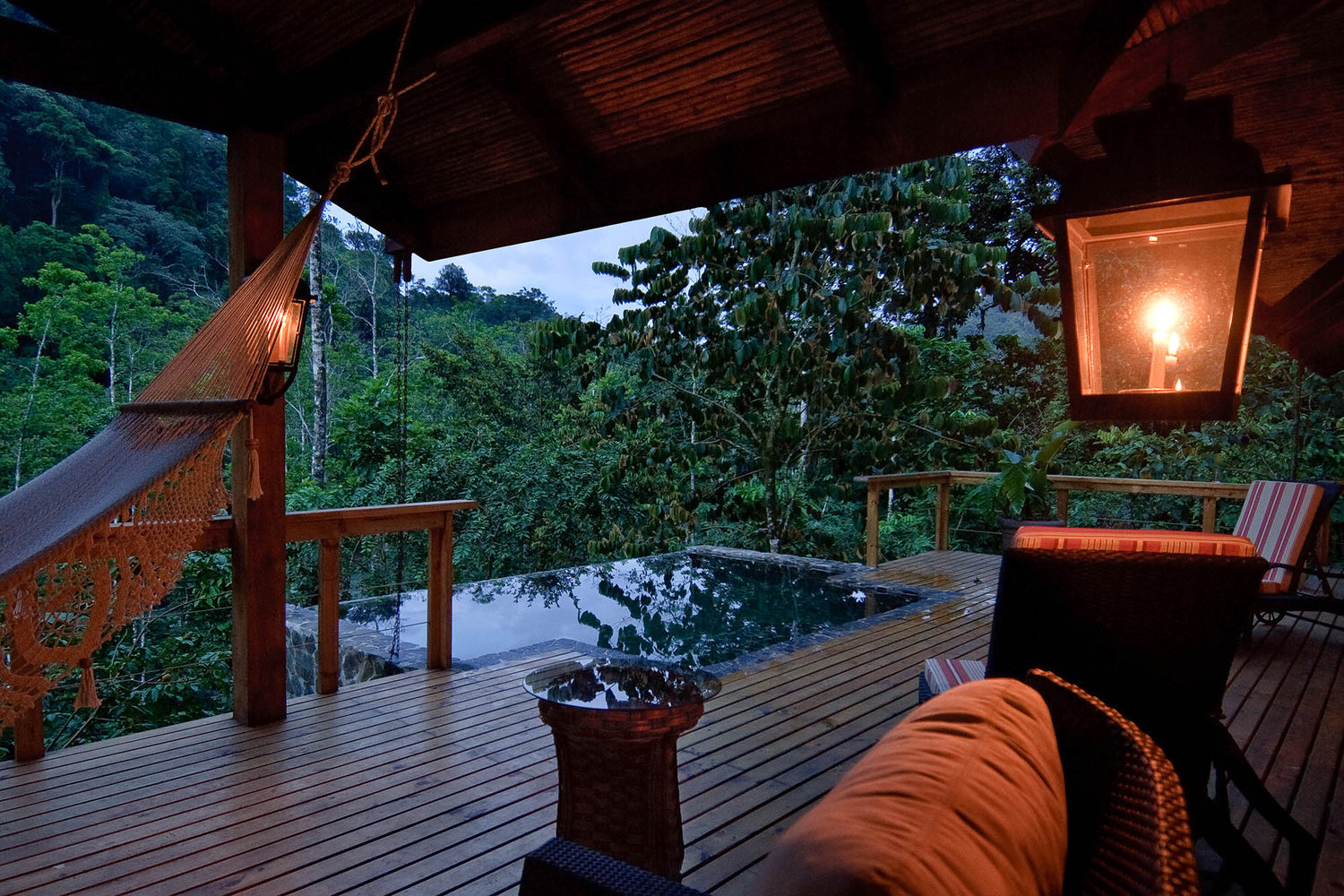 Wooden deck with hot tub and view of trees at night; Pacuare Lodge, Costa Rica plunge pool