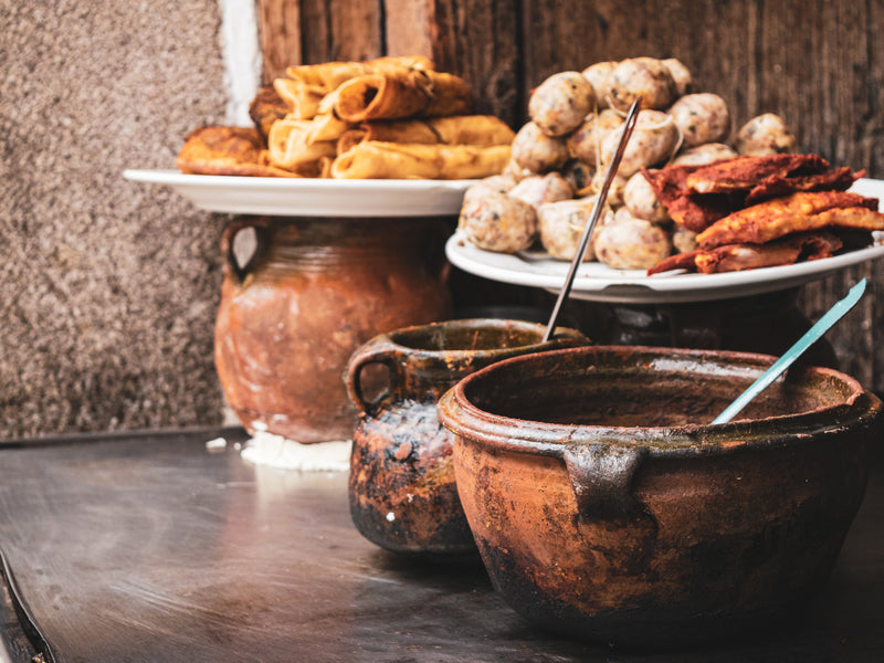Traditional food items including bread, potatoes, and meat on a rustic wooden table; Antigua street food, Guatemala, Mayan