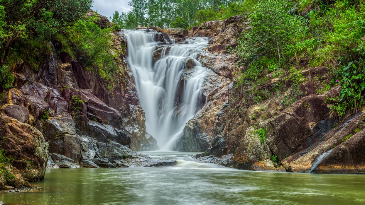 Waterfall surrounded by rocky cliffs and lush greenery Belize Big Rock Falls Mountain Pine Ridge