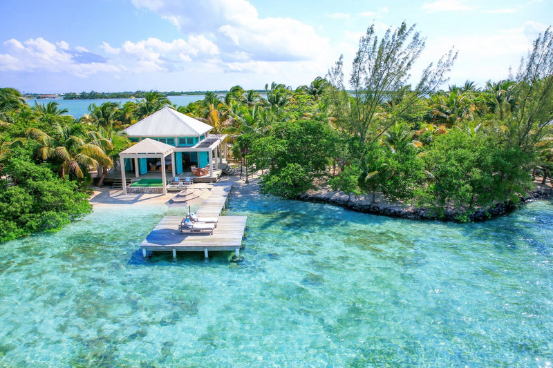 Luxury villa with dock on a tropical island with clear blue water and lush greenery; Belize private island Cayo Espanto, plunge pool honeymoon