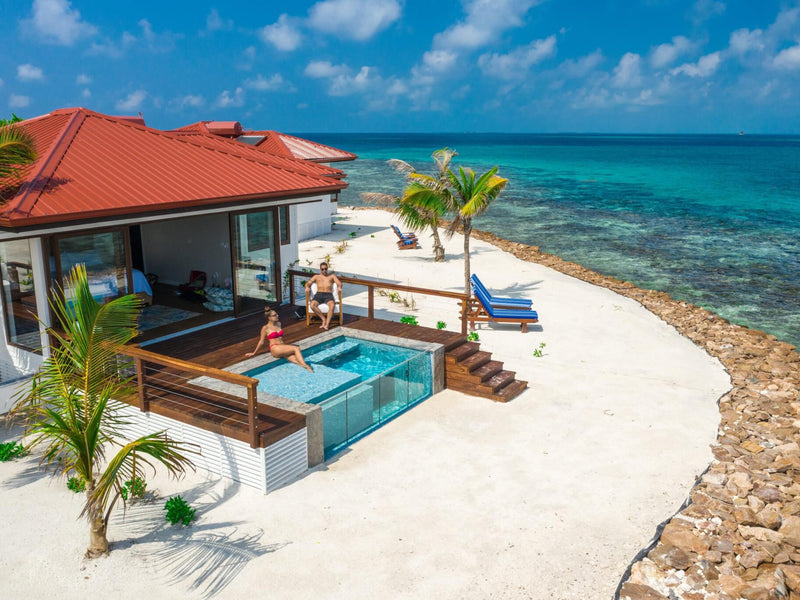 Homes with a pool overlooking the ocean on a sunny day; Ray Caye private island plunge pool Belize