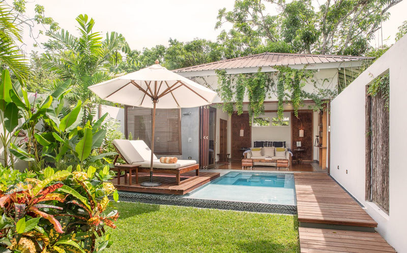 Outdoor patio area with pool, lounge chairs, and umbrella in a tropical setting; Kaana Belize, San Ignacio, Cayo District, private villa with plunge pool