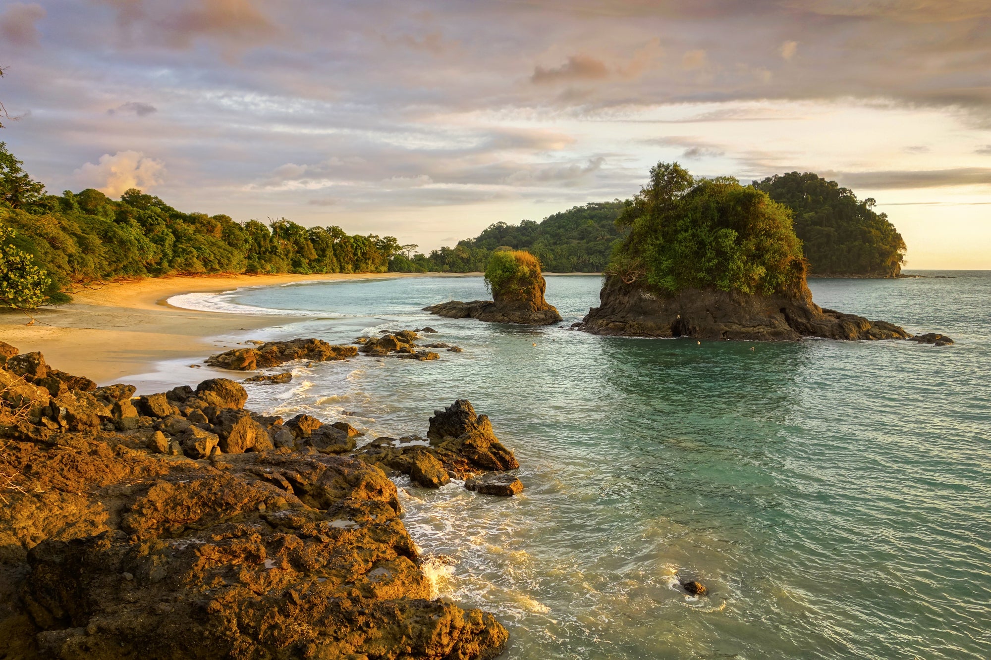 Beach scene with rocky outcrops and trees at sunset; Manuel Antonio Costa Rica
