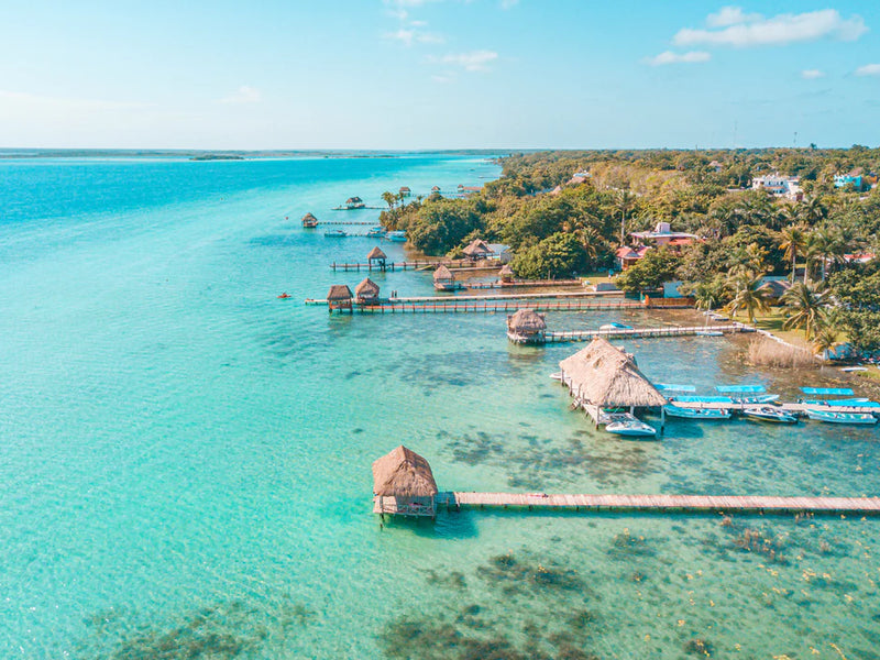 Turquoise waters with overwater bungalows and a clear blue sky. Bacalar, Yucatan, Mexico.