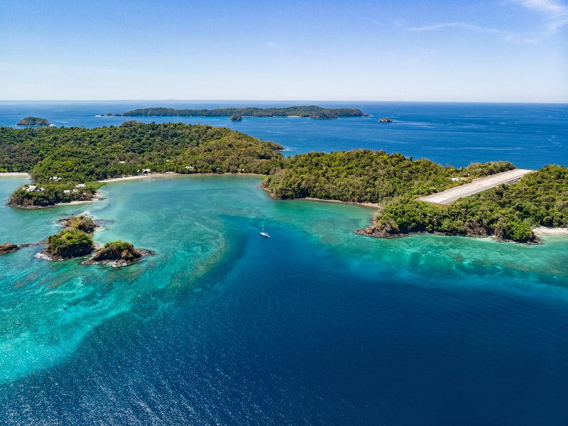 Aerial view of a tropical island with clear blue water and lush greenery Panama Islas Secas