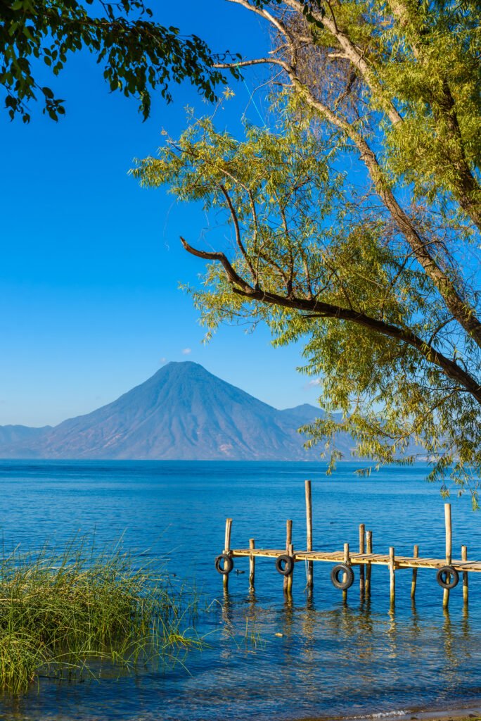 Wooden pier at Lake Atitlan on the shore at Panajachel, Guatemala. With beautiful landscape scenery of volcanoes Toliman, Atitlan and San Pedro in the background.