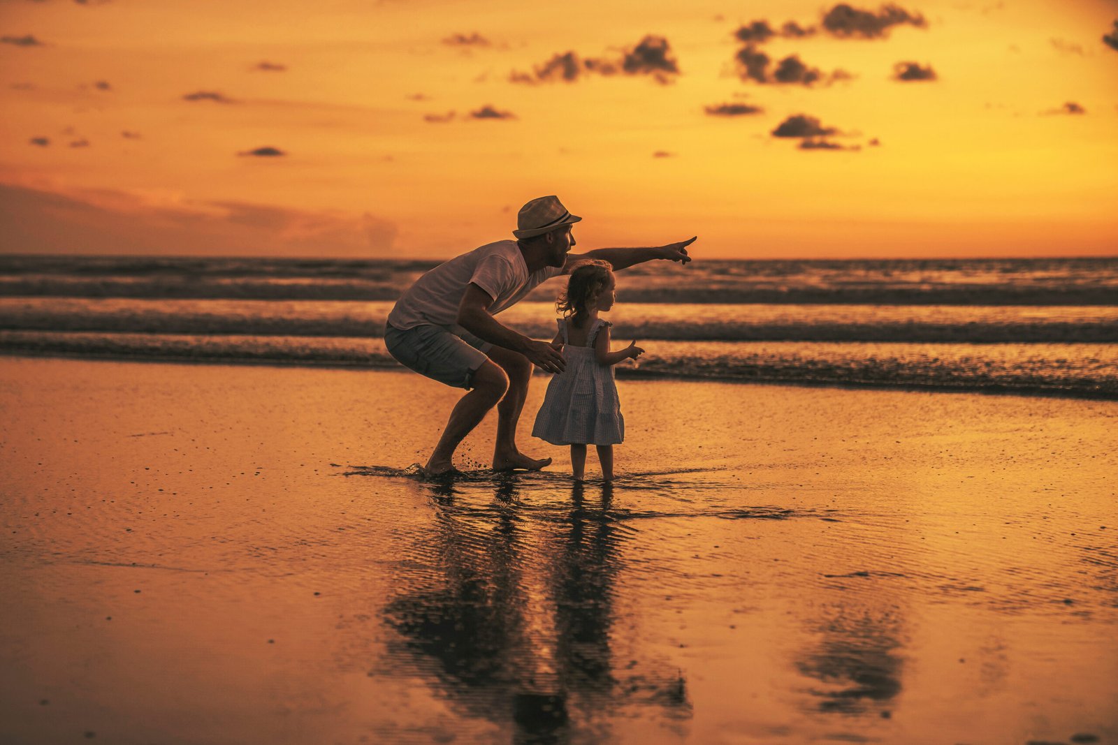 happy family at the beach a father and baby daughter having fun at sunset